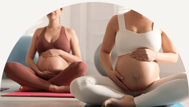 Group of women sitting cross-legged on mats caressing baby belly and practicing breaths